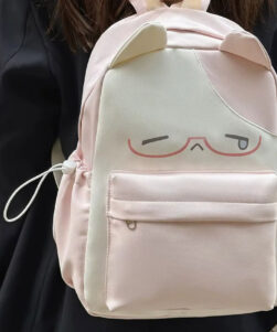 Teen girl wearing pink kawaii cat backpack with ears and color block canvas design, lifestyle front view